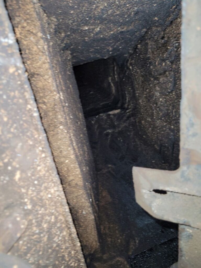 Interior view of a chimney's smoke chamber showing heavy soot accumulation.