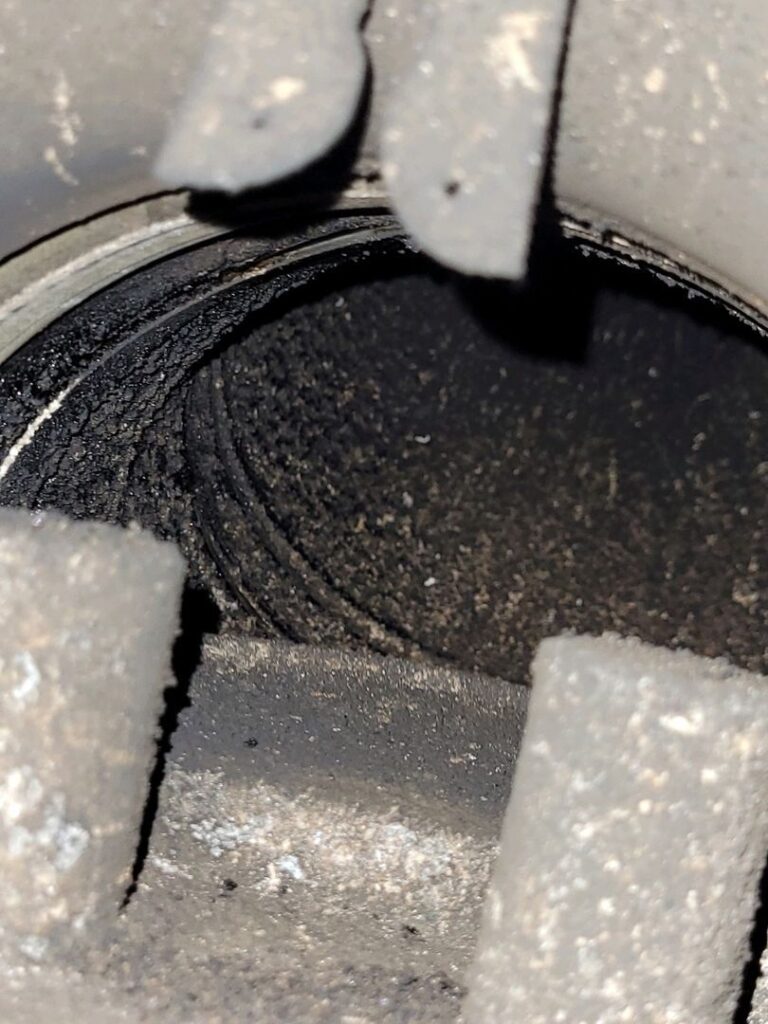 Interior view of a chimney with a thick layer of black creosote coating its surface