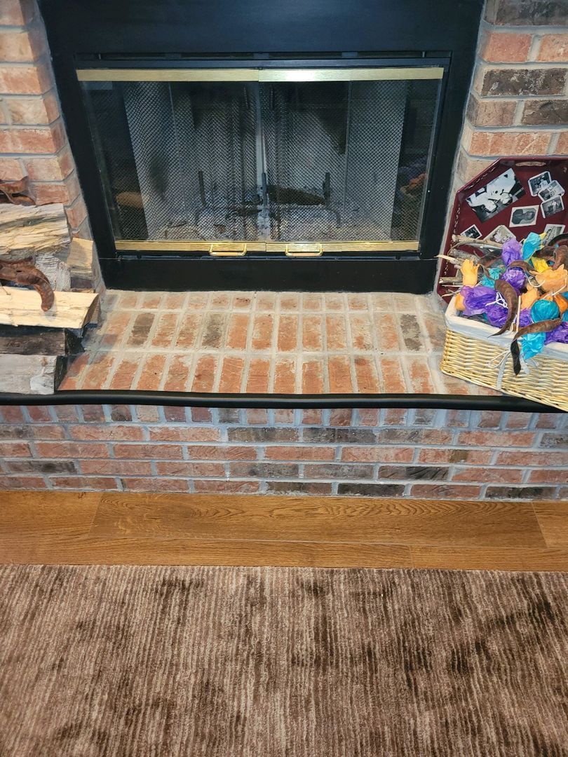 A detailed view of a closed prefab fireplace with decorations on the brick hearth