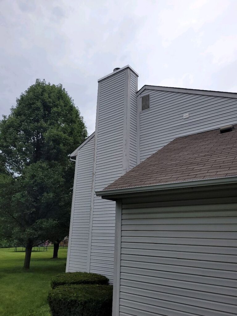 Image of a residential building with a new shiny chase cover on the chimney